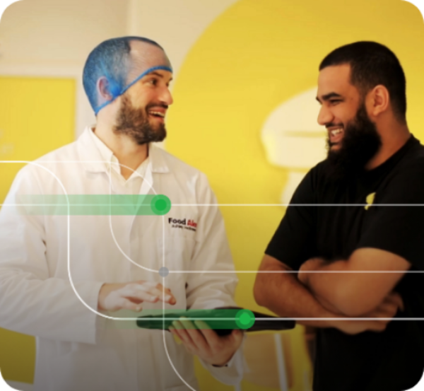 A man running an independent food check, talking to another man both are smiling.